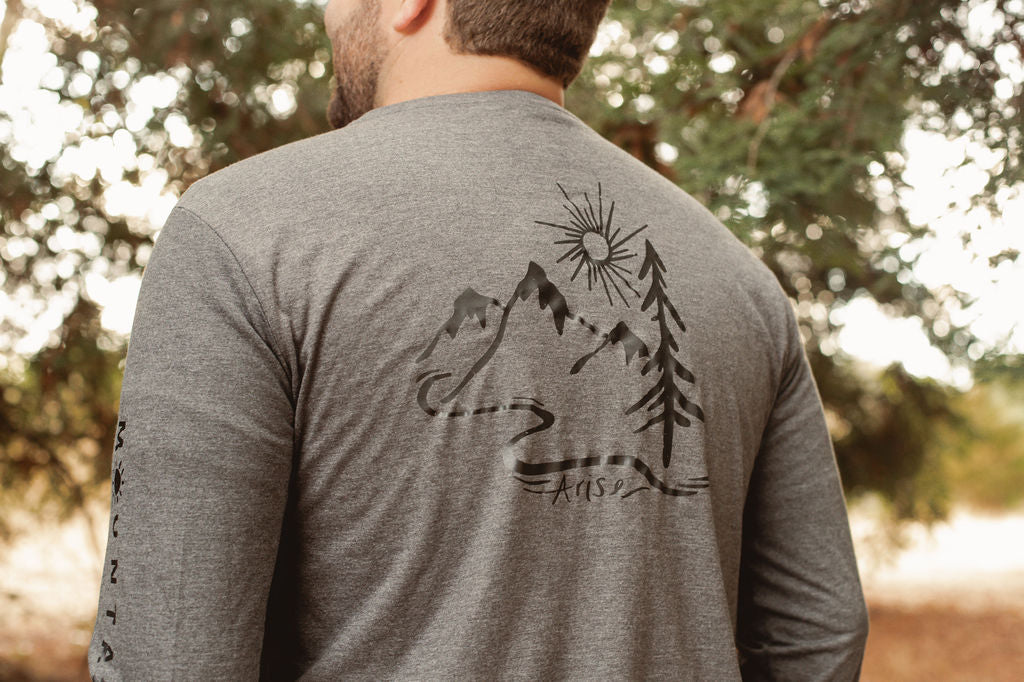 Back of Happy Henley long sleeve tee. Black arise logo featuring mountain, tree and sun