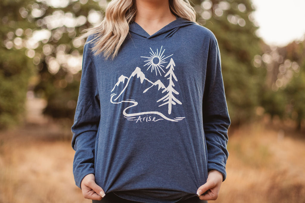 Navy hooded tee with stamped white mountain, tree and sun with the word Arise