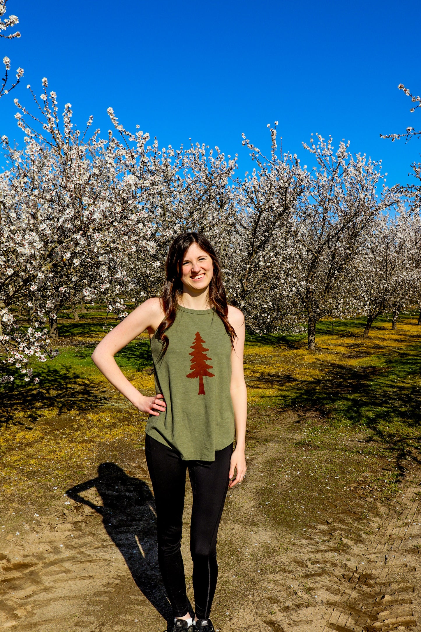 woman wearing green tank with tree stamp