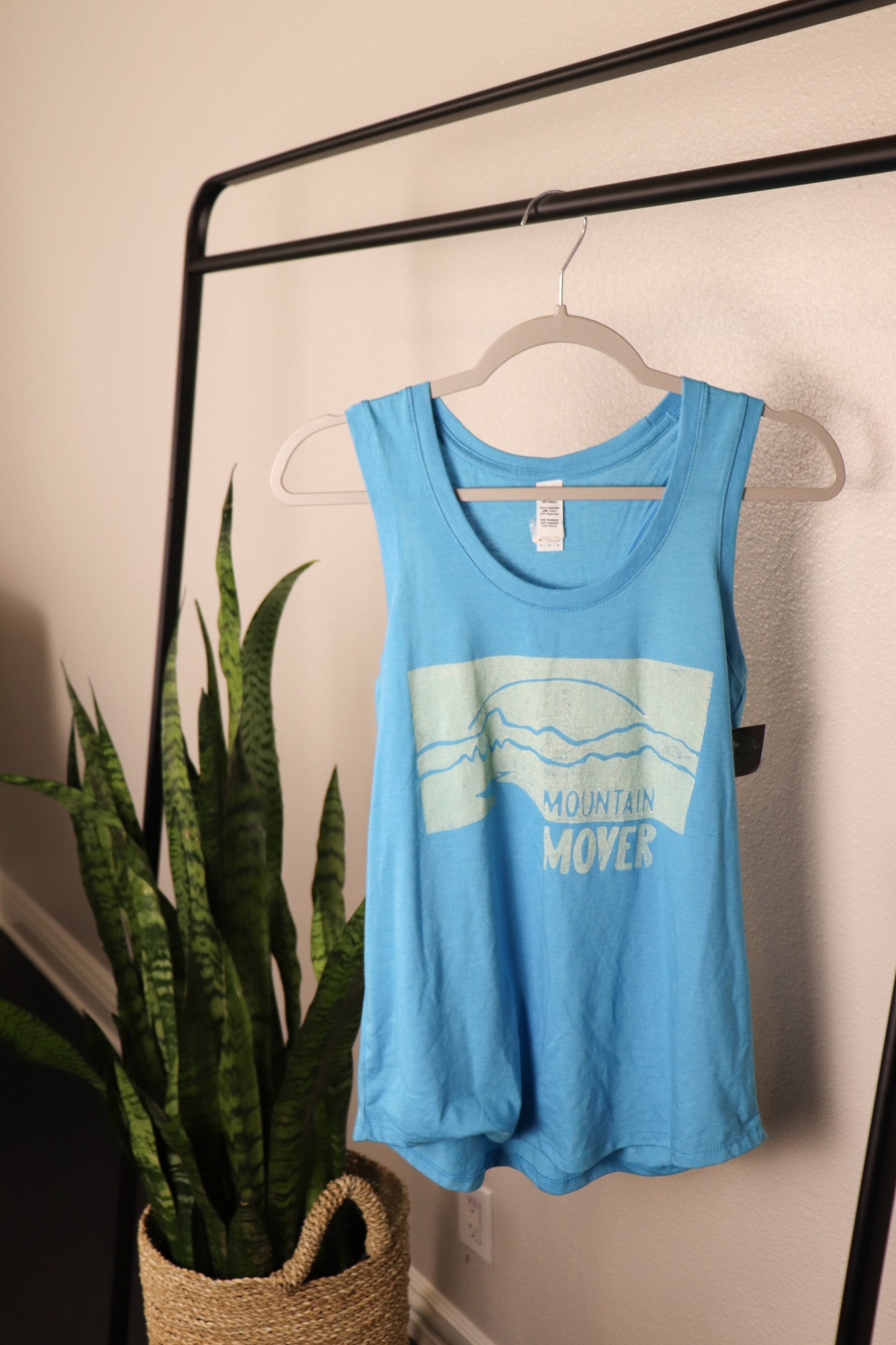 Light blue tank top with white mountain mover stamp depicting a mountain scene