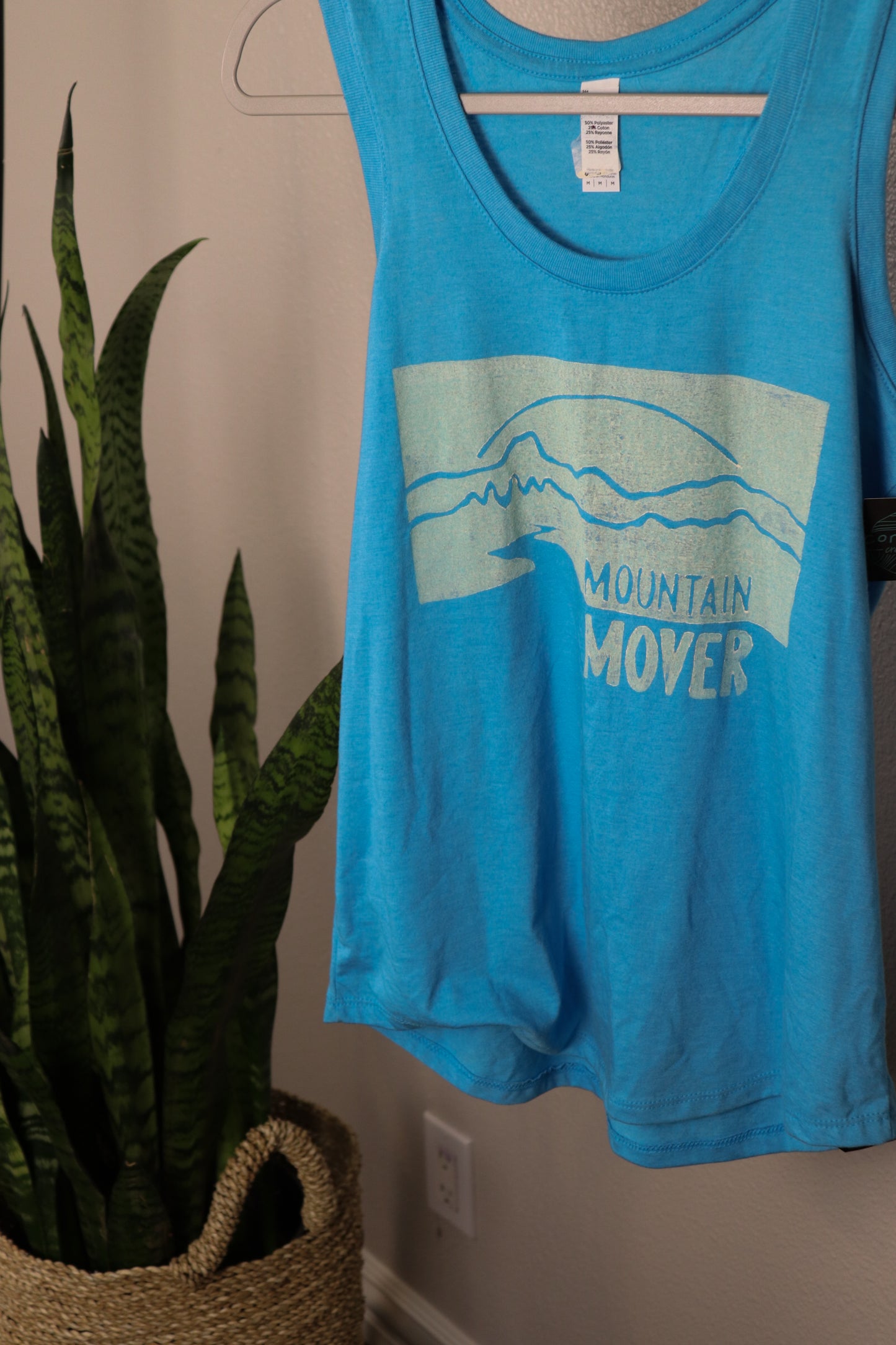 Light blue tank top with white mountain mover stamp depicting a mountain scene